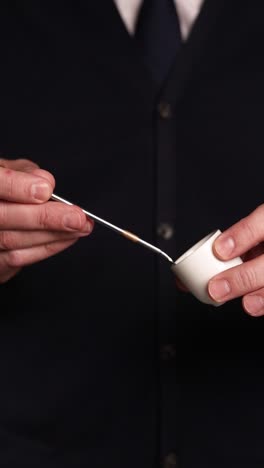 man pouring liquid from a spoon into a small dish