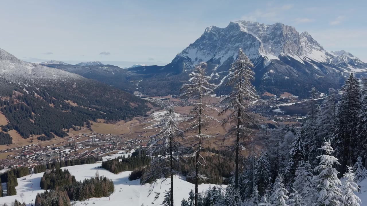 Pemandangan pegunungan panorama lembah musim dingin dengan desa dan puncak Alpen. Pemandangan dari lift. Diambil dengan ponsel pintar.