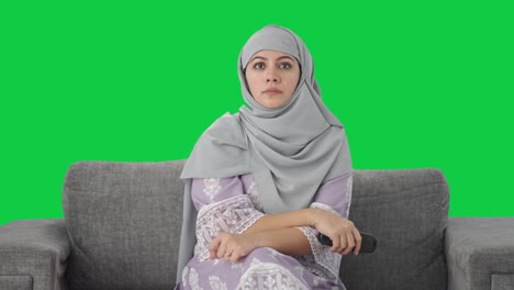 muslim woman watching television at home green screen