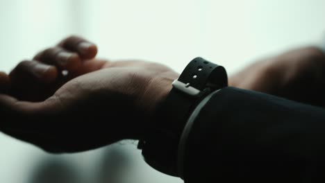 hombre de negocios confiado en traje azul clásico con o ajustar reloj con corbata cerca de la ventana en la habitación del hotel. hombre guapo con un buen traje en el día de la boda.