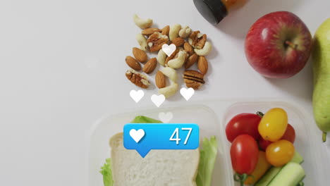 social media likes animation over healthy lunch with nuts, sandwich, and fruits