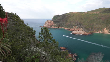 a boat cruise over the bar in the knysna heads on its way in summer out to sea on the indian ocean from above