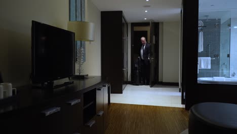 businessman in a suit enters his hotel room after checking in