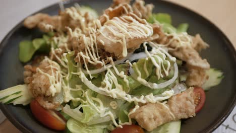 rotating-view-of-a-bowl-of-salad-full-with-vegetable-and-fried-crab-shell