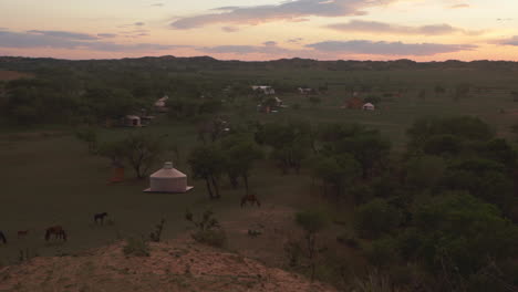 Jurtencampingplatz-Mit-Pferden-Im-Mongolischen-Grasland-Bei-Sonnenuntergang