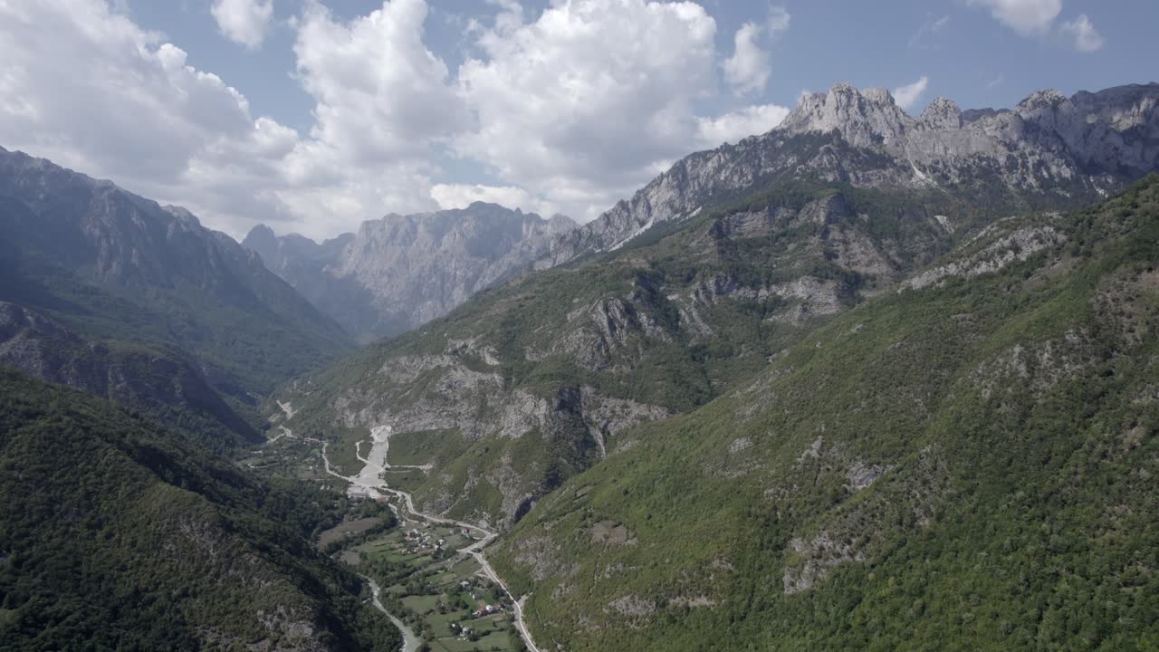 video frontal de drones que avanza sobre el valle de valbone, albania, condado de rogam, se pueden ver casas pequeñas y el río con poca agua
