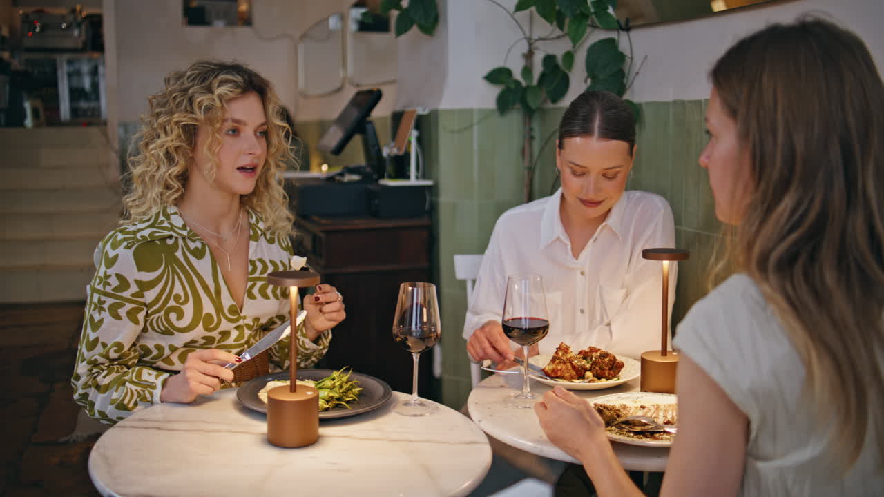 Group women engaged conversation dining at restaurant closeup. Three ladies