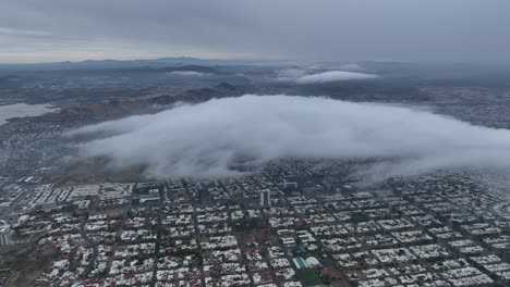 aerial shot of drone flying over city in cloudy day