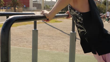 person working out on outdoor parallel bars in a city park