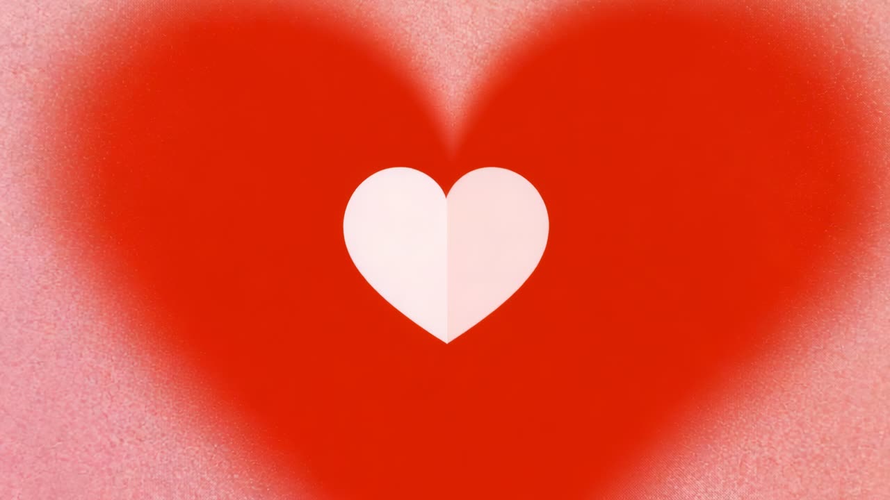 Appare un piccolo cuore bianco nitido che sollecita un cuore rosso che diventa sfocato e riempie l'inquadratura su un gradiente rosa