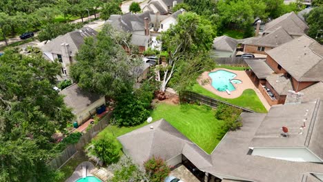 An-aerial-shot-of-a-fallen,-destructive-tree,-located-in-a-residential-backyard,-recorded-at-60-frames