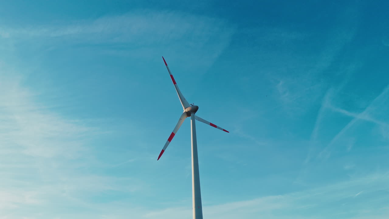 Veduta aerea di una turbina eolica al tramonto con luce calda e nuvole sullo sfondo