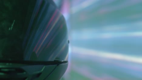 extreme close-up of a motorcycle helmet reflecting vibrant streaks of purple and blue light. this shot creates a sense of high-speed travel through a futuristic, neon-lit city or tunnel at night.