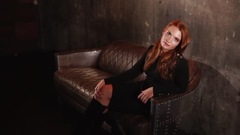 woman in black dress on leather couch