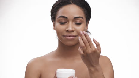 mujer aplicando crema facial