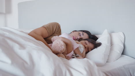 Peaceful-Mother-And-Daughter-Sleeping-In-Bed-Together