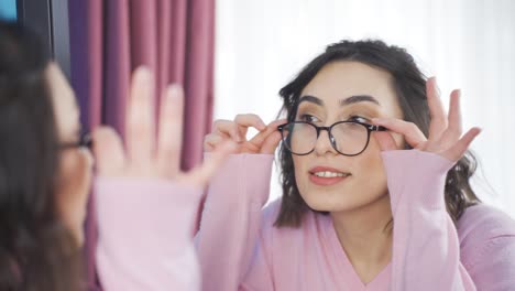 cute and cheerful young woman in front of the mirror.