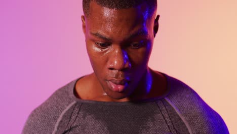retrato de un corredor afroamericano con ropa deportiva sobre iluminación rosada