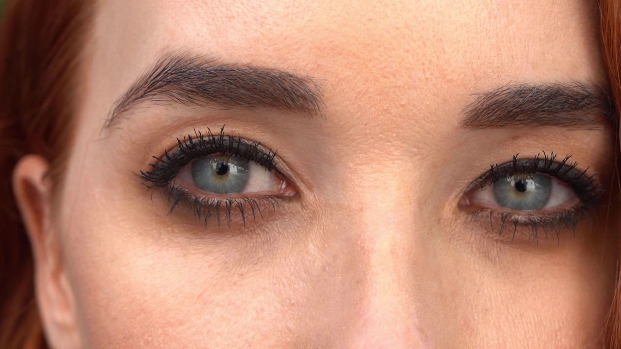 Woman s face girl opening her beautiful blue eyes
