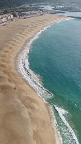 aerial view of a sandy beach with turquoise ocean waves