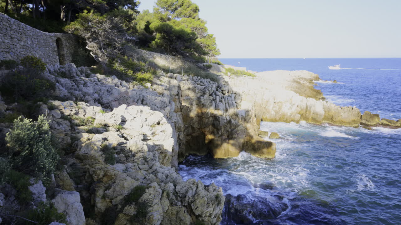 The waves of the Mediterranean Sea crashing on the rocks on the shore of the French Riviera