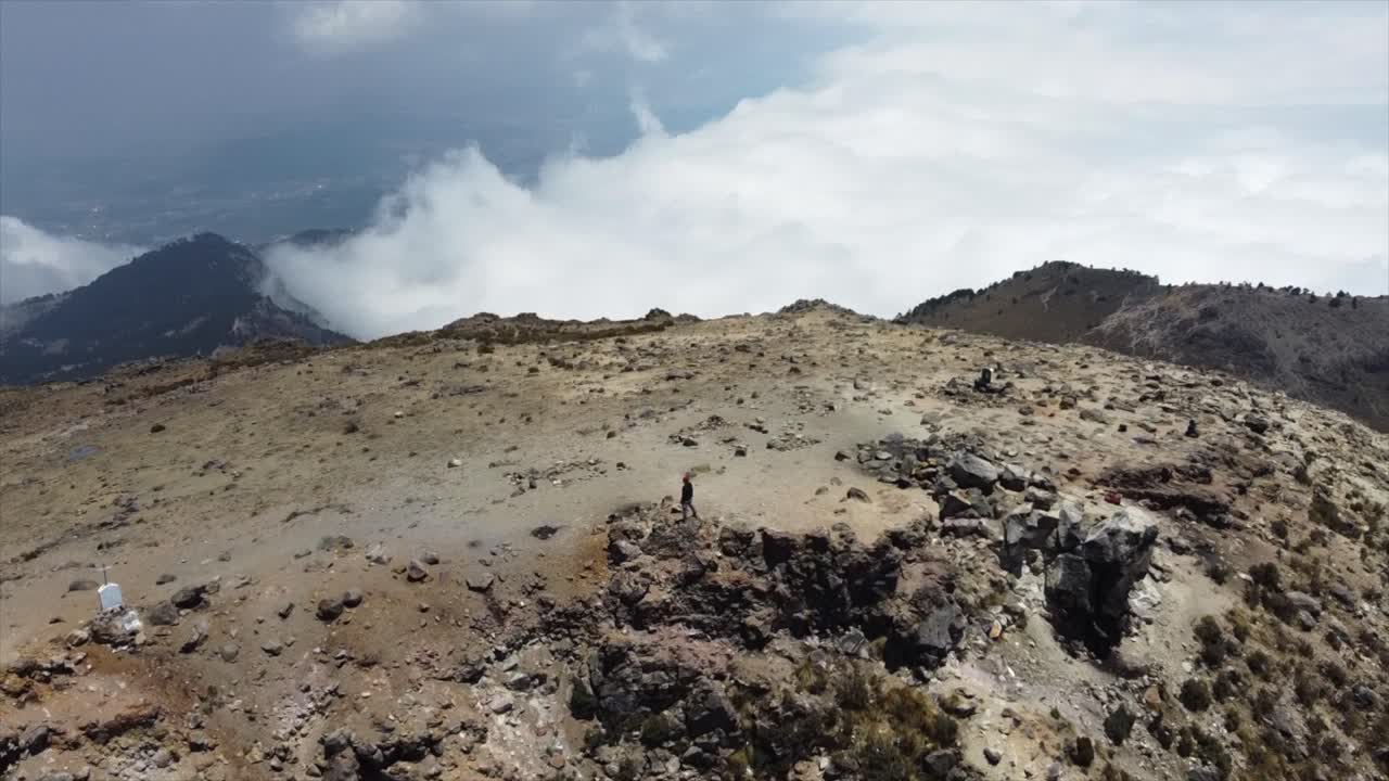 órbita aérea persona de pie en la cumbre de la montaña por encima de las nubes