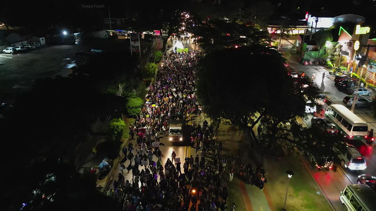 Slow night flyover of Women's Day march on busy street, Santa Cruz BOL