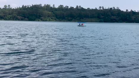 Lonely-boat-floating-in-lake-with-the-boatman-and-making-round-in-calm-lake