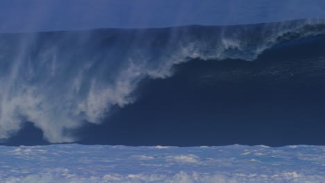 medium view of wall of water crashing with mist spray rising above, tracking pan in slow motion