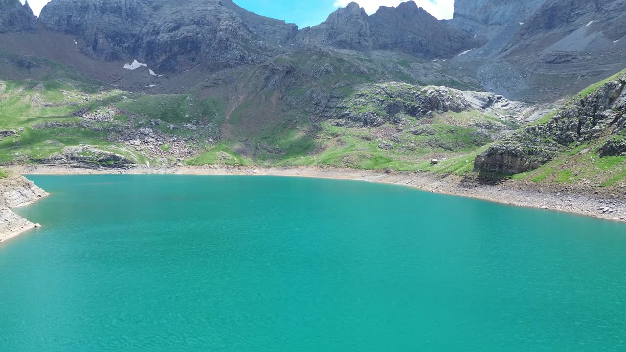 Aerial zoom in reveals turquoise waters surrounded by steep mountains in Valle de Ip, Aragon