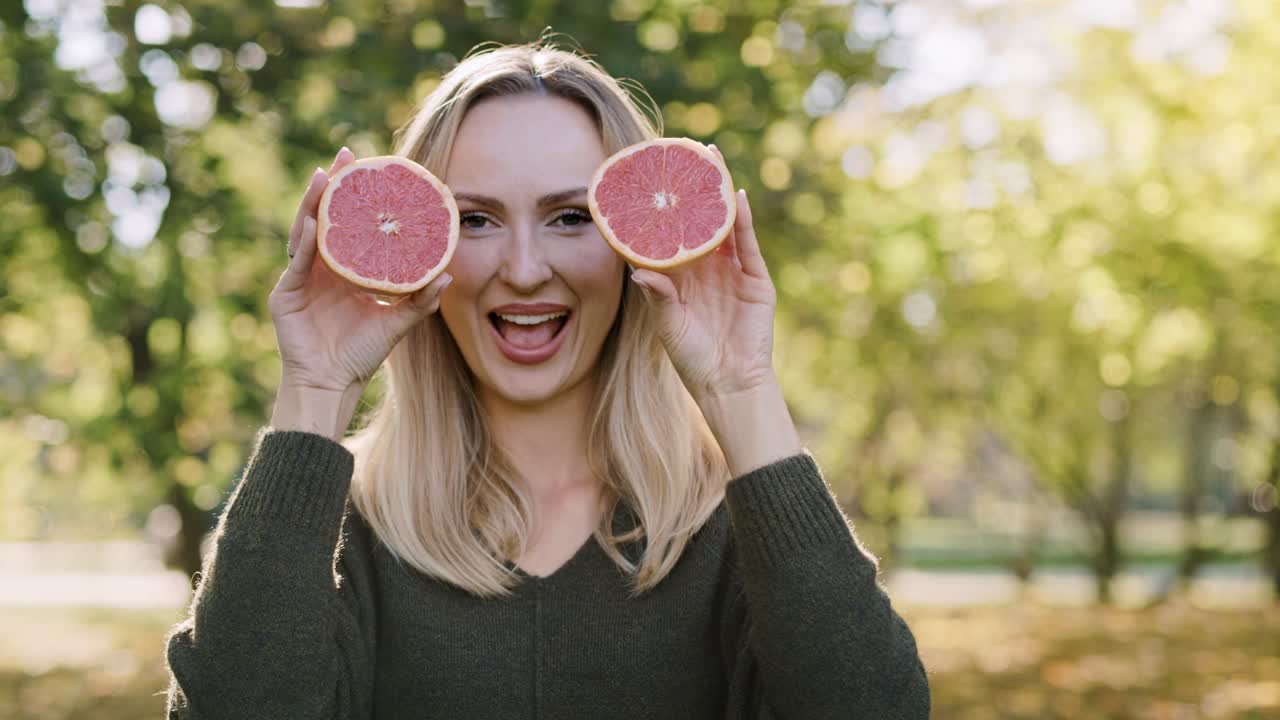 Handheld view of woman making a funny face with fruit