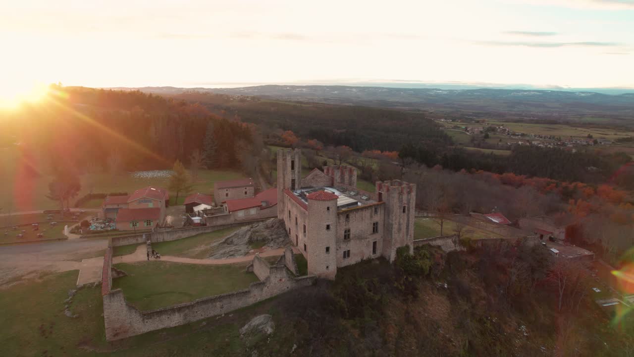 aerial drone shot around Essalois Castle in the Gorges de la Loire in french countryside at sunset, loire departement, auvergne rhone alpes region, France