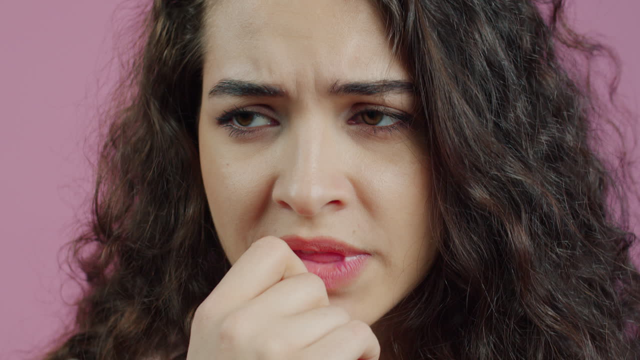 Woman with worried expression biting nails