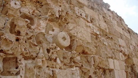 aged limestone wall with many marks of time in salamis city, cyprus