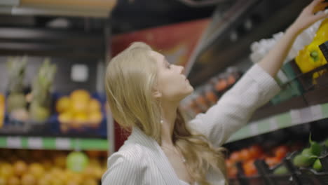 mujer comprando pimienta amarilla en el supermercado. mujer tomando y eligiendo verduras orgánicas en la tienda de comestibles. compras de cero residuos y concepto de estilo de vida saludable. cámara lenta.