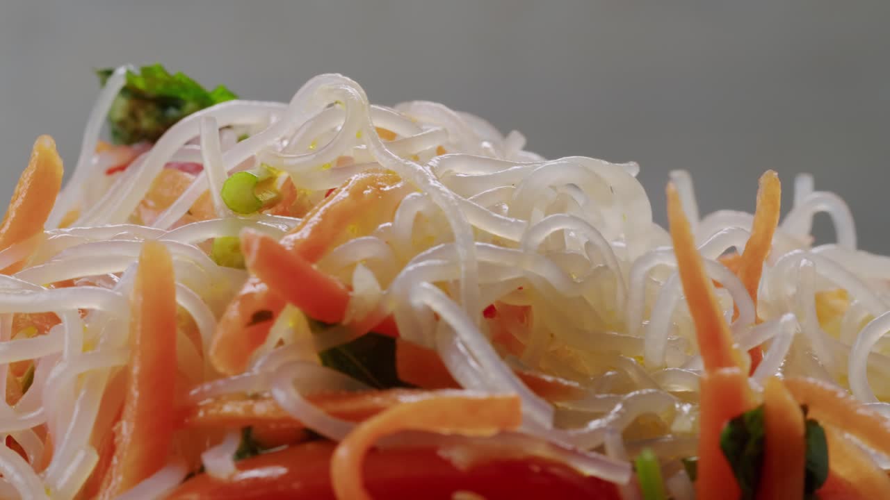 Glass noodles salad with meat and carrots fermented close up asian chinese traditional food.