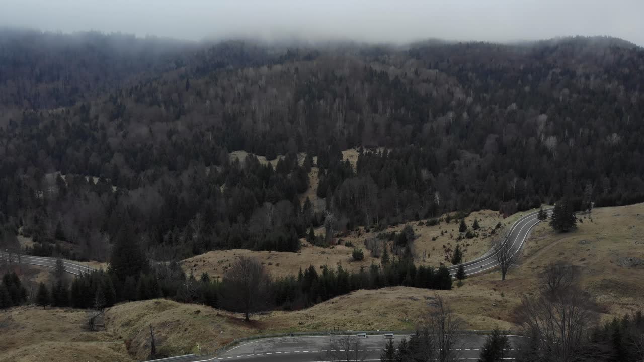 vista panorámica de una carretera de montaña con árboles densos contra el cielo nublado