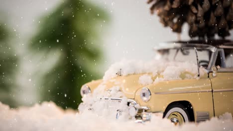 Model-car-with-a-fir-cone-on-its-roof-on-a-carpet-combined-with-falling-snow
