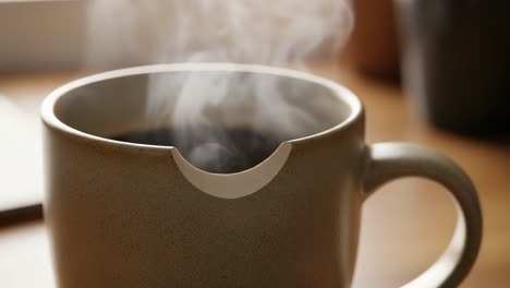 aesthetic close-up of a steaming coffee cup with unique design features showcasing the serenity of morning rituals and cozy ambiance