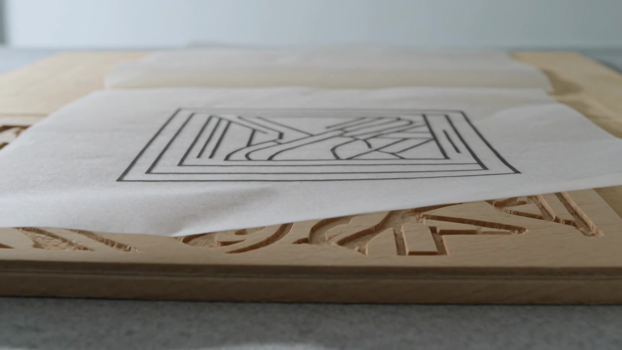 Revealing camera pulling back on table, exposing carved wooden block edge beneath thin white sheet