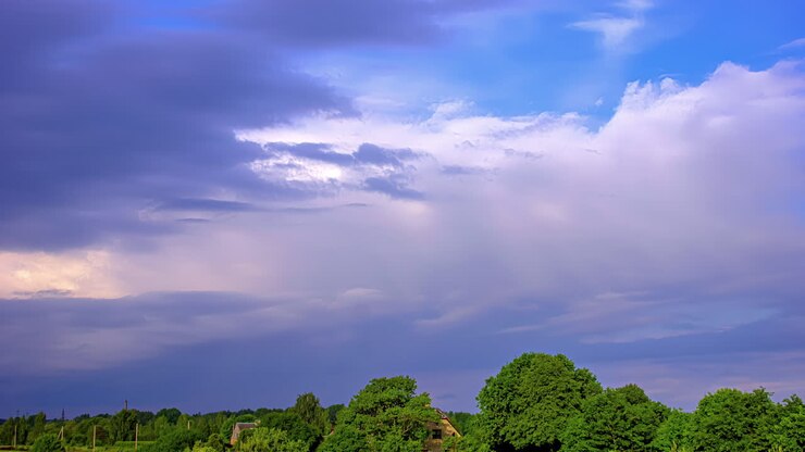 Colorful timelapse of clouds moving over a green forest in Europe in summertime