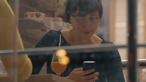 Women-having-friendly-meeting-in-cafe-and-being-attracted-with-mobiles