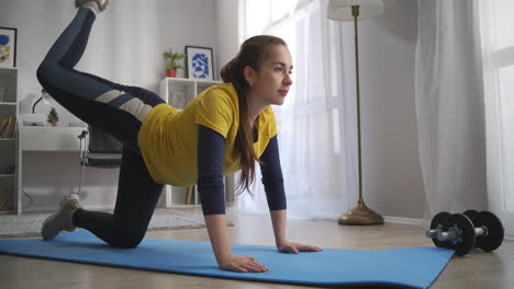 aerobic training at home young woman is tensing muscles of legs doing physical exercises on floor in living room sport activity and healthy lifestyle