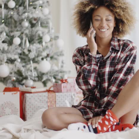 Mujer-Joven-Que-Se-Relaja-Delante-De-Un-árbol-De-Navidad