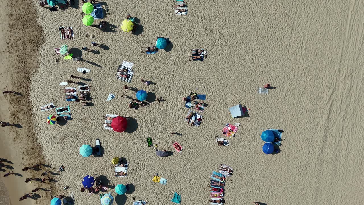Aerial view of a beach with people and umbrellas