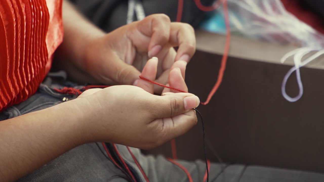Handheld close up of an indigenous woman doing her handcrafts at 120fps