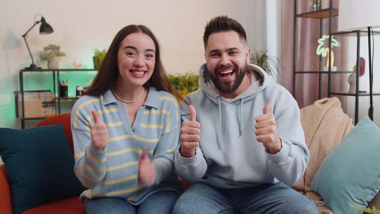 Happy family man woman looking approvingly at camera showing thumbs up like positive sign good news