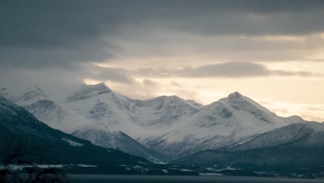 Beautiful-Time-Lapse-of-clouds-passing-by-tall-snowy-mountains-in-Norway,-Molde