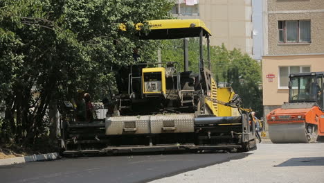 vinnitsa, ukraine - july 2017: workers making asphalt with special equipment at road construction