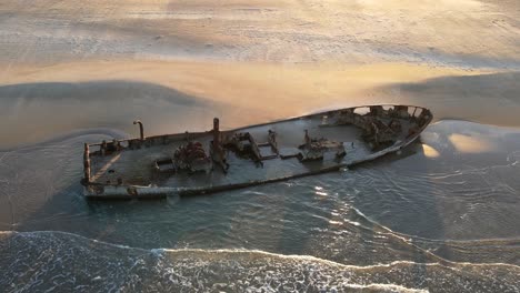 aerial view of wrecked boat, on the shoreline , on the beach in moshav habonim old shipwreck in habonim beach in israel